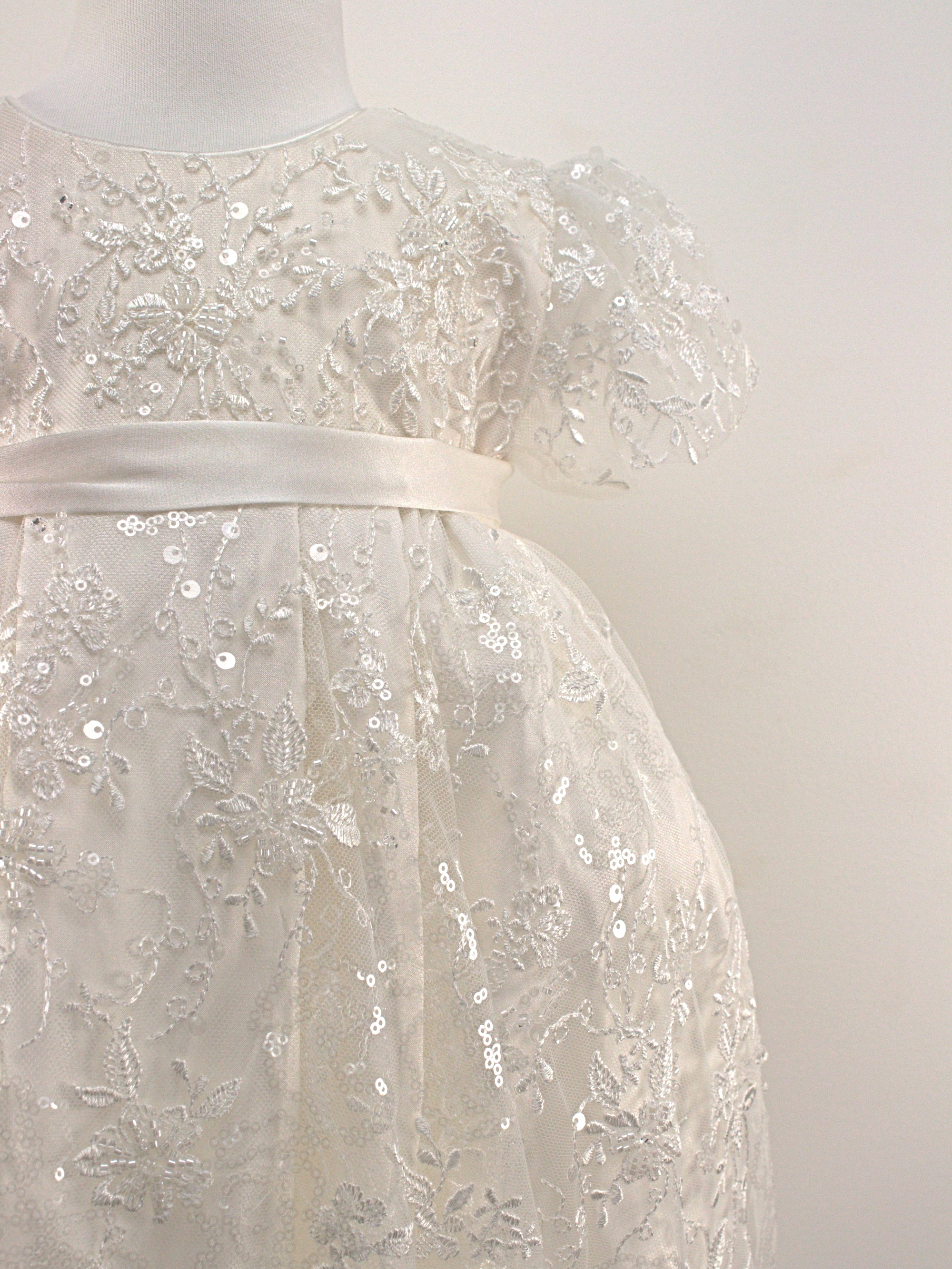 Close-up of the My Blessing Eternal christening gown’s front bodice showing detailed floral lace and bead embroidery.