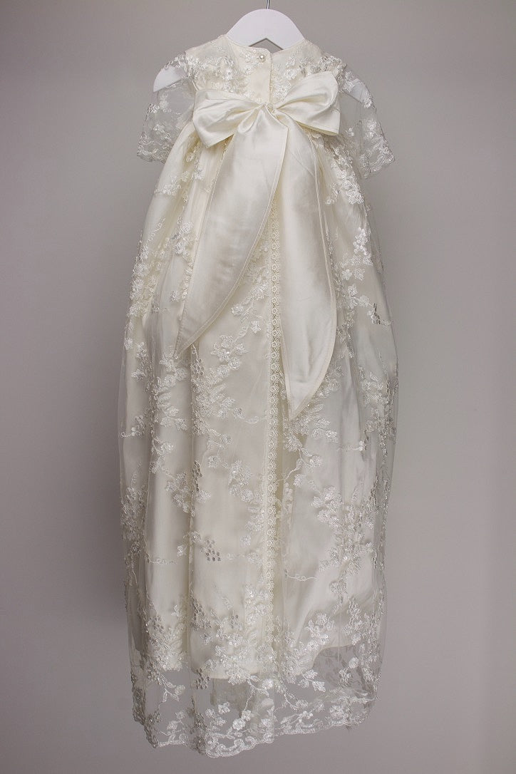 Back view of the My Blessing Faith christening gown showing the flowing lace overlay and smooth pure silk mid‑layer.