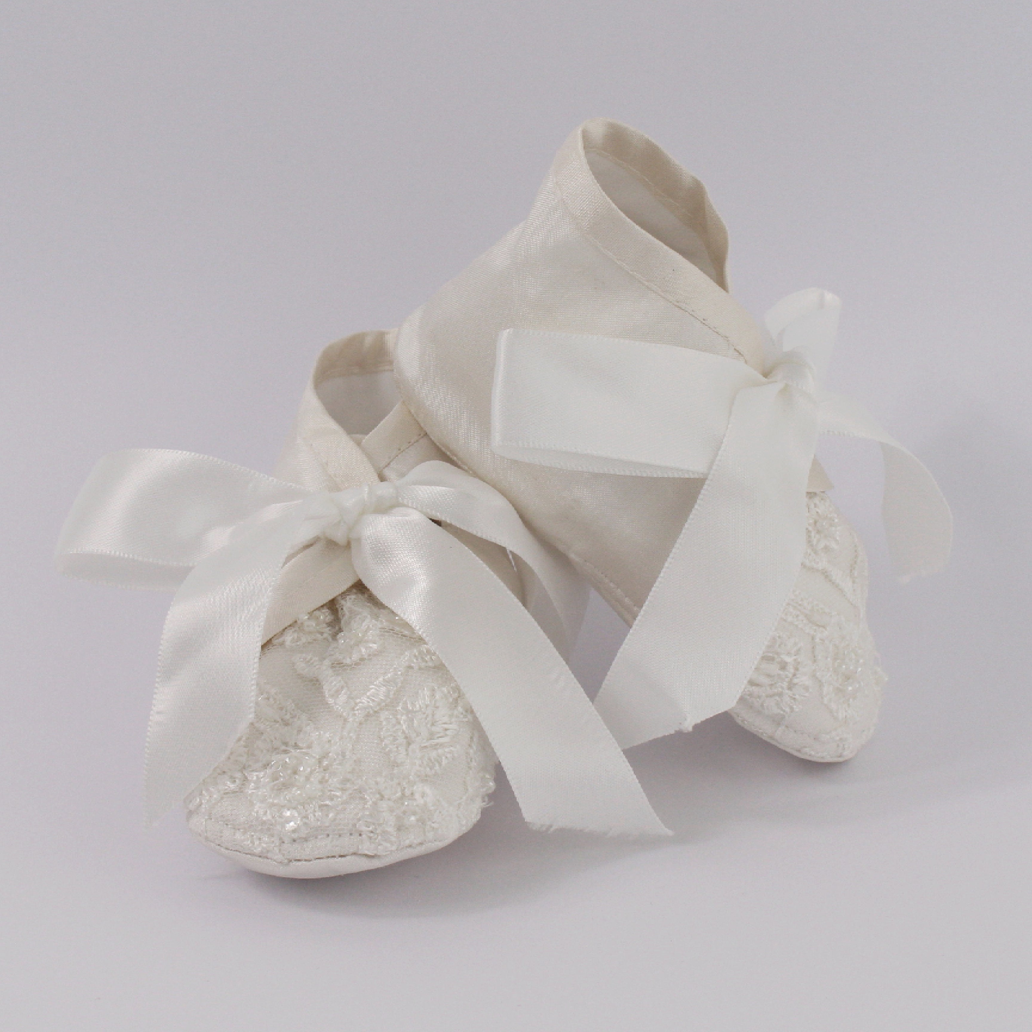 Ivory christening shoes from the My Blessing Faith set featuring European lace with subtle glass seed bead detailing.
