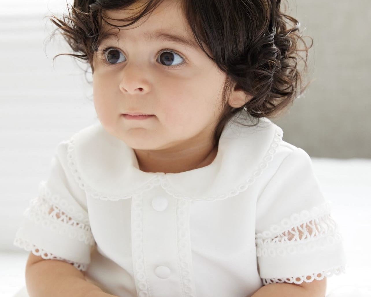 Close-up of the My Blessing Georgie romper showing the smooth Mikado fabric and refined front panel detailing.