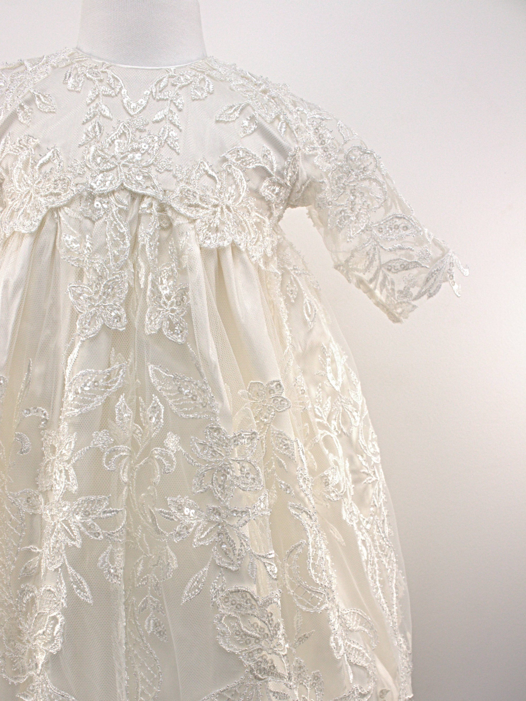 My Blessing Glorious ivory christening gown featuring an embroidered lace bodice, short sleeves, and a flowing satin skirt.
