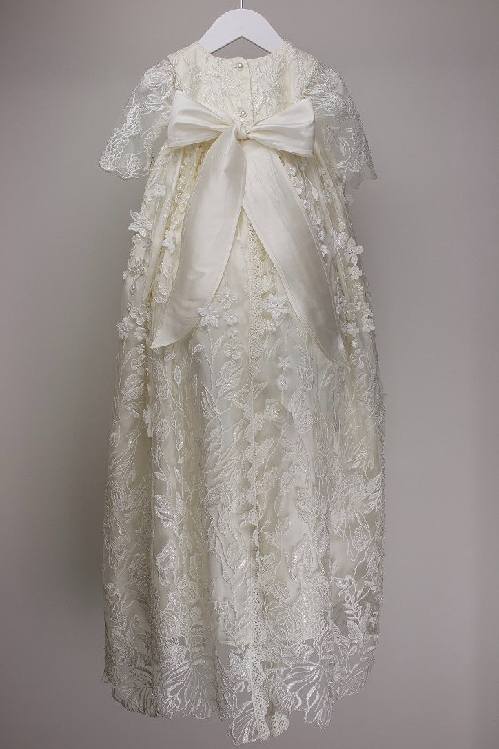 Back view of the My Blessing Humble christening gown showing the flowing European lace overlay and smooth silk mid‑layer beneath.