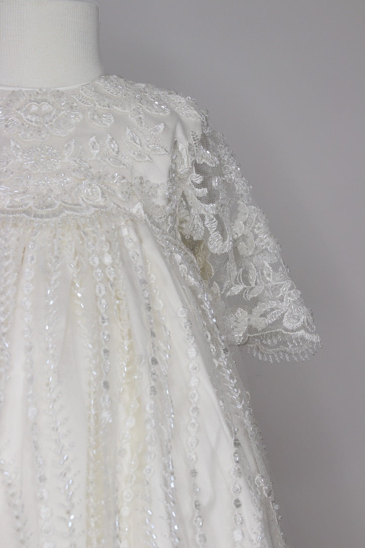 Close-up of the My Blessing Nineveh gown’s front bodice showing intricate floral lace embroidery layered over a smooth silk underlay.