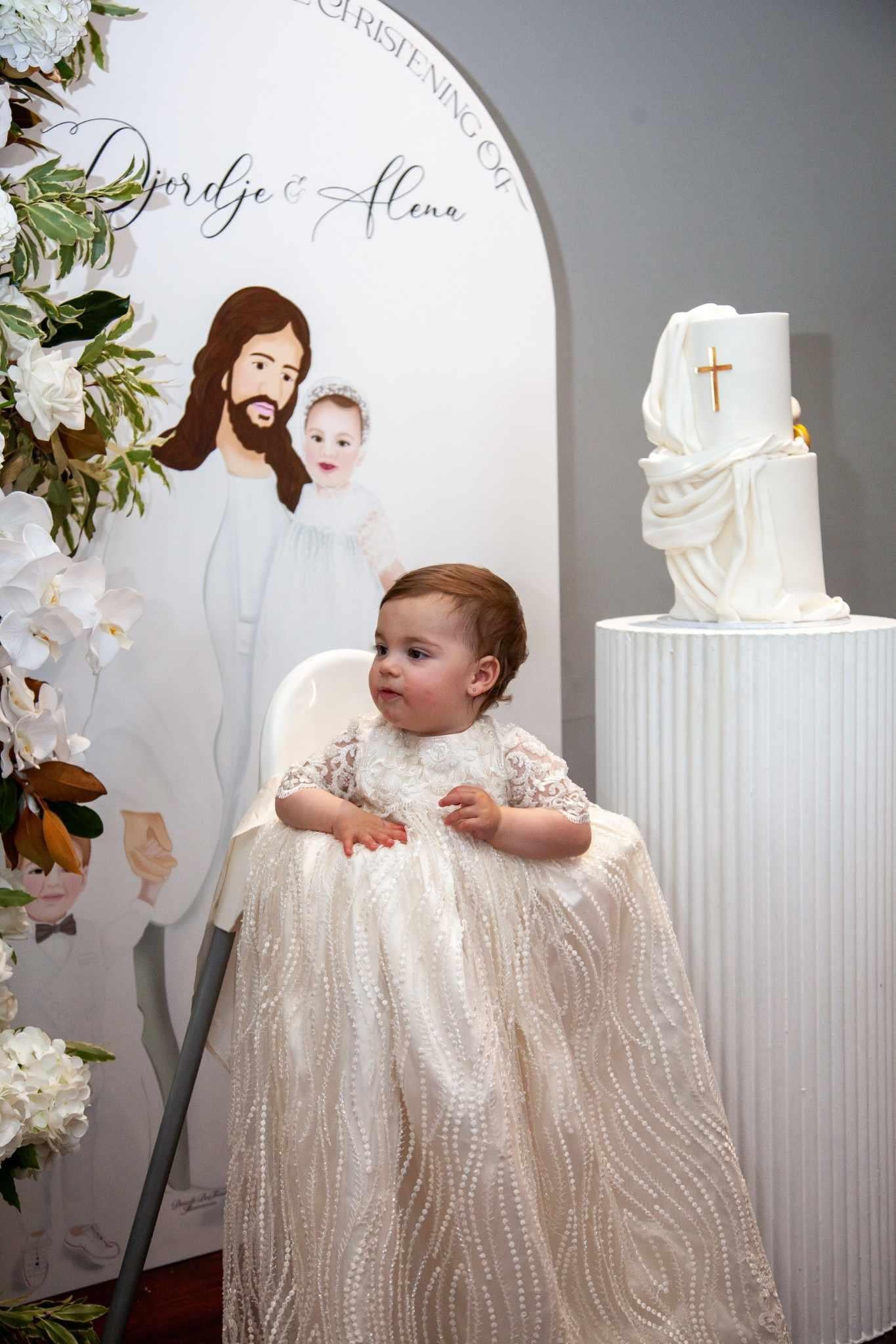 My Blessing ivory christening gown from the Nineveh exclusive release featuring an embroidered lace detailing, elegant sleeves, and a flowing silk underlay skirt.