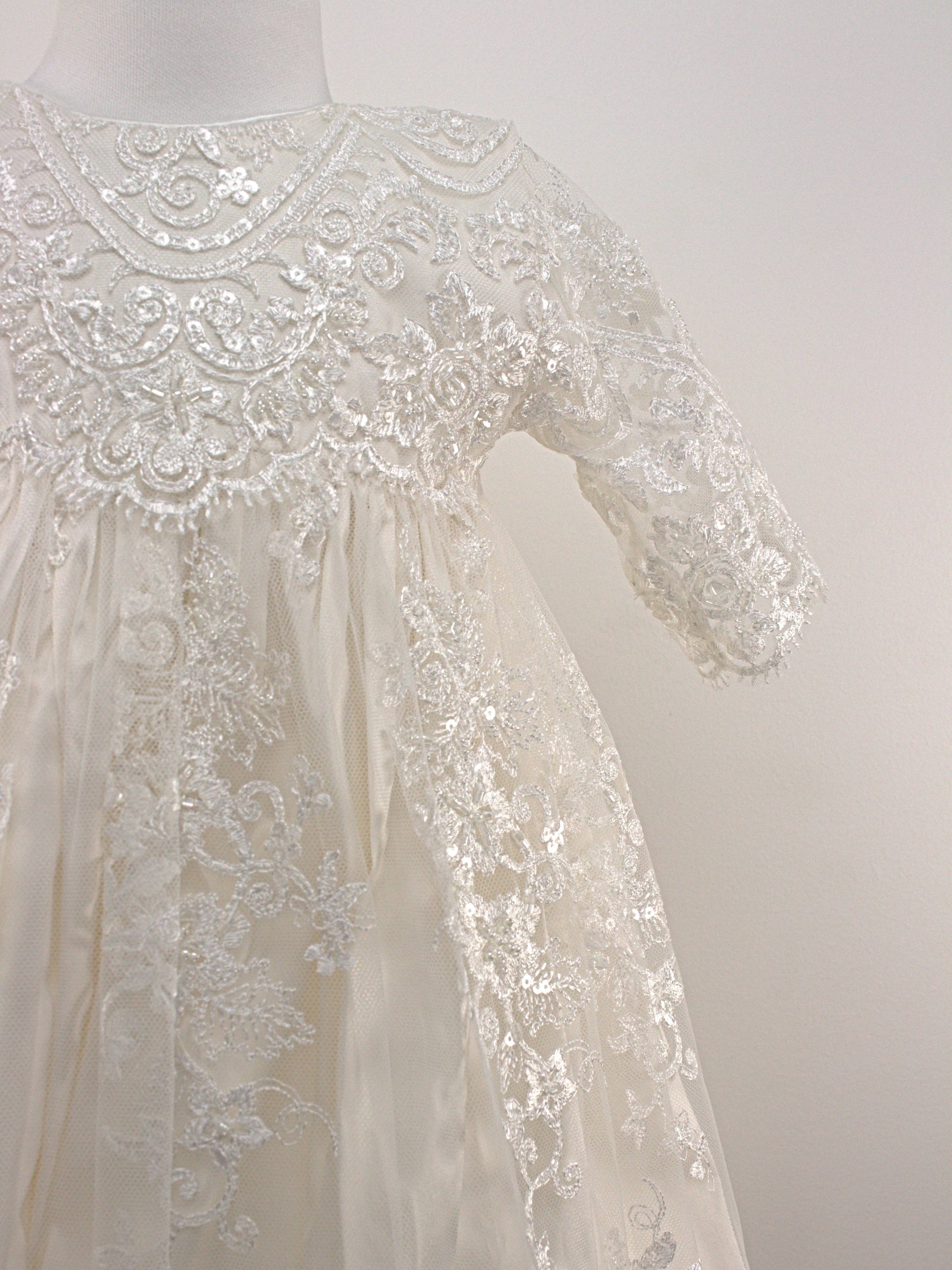 My Blessing Noble ivory christening gown featuring an embroidered lace bodice, short sleeves, and a flowing satin skirt.