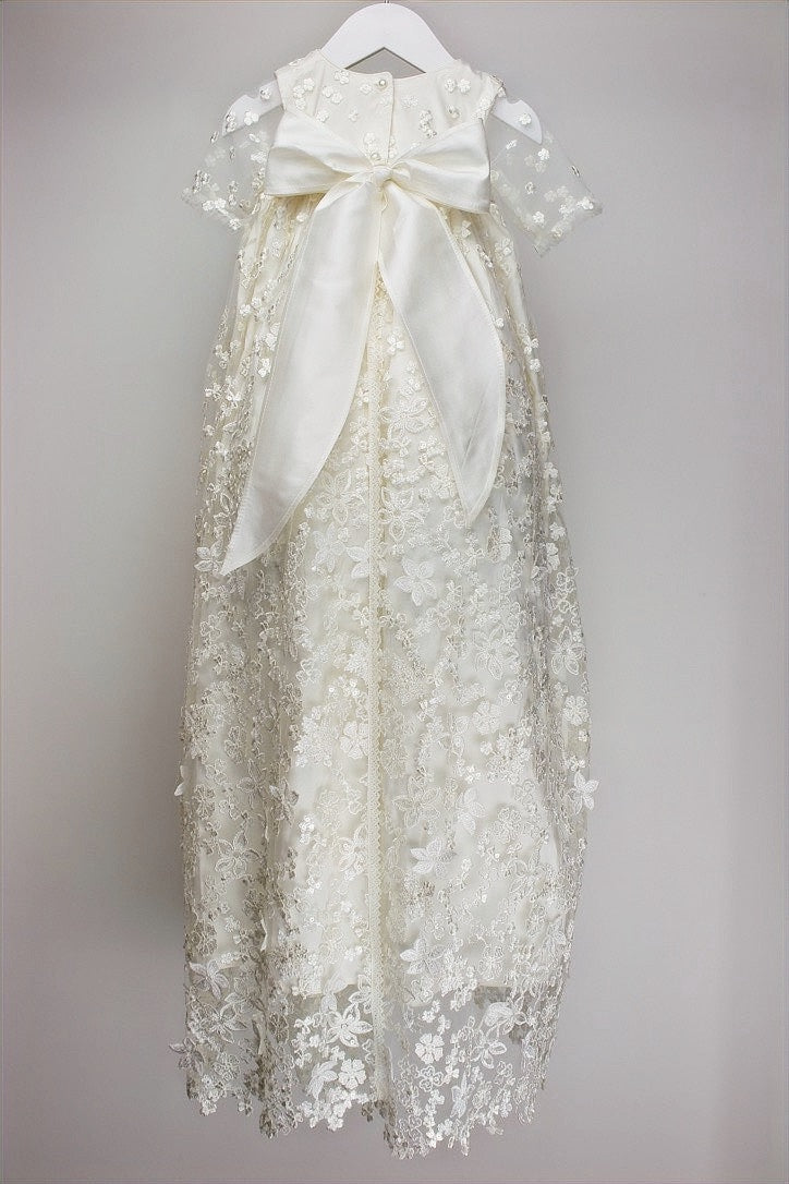 Back view of the My Blessing Promise christening gown showing the flowing lace overlay and smooth pure silk mid‑layer.