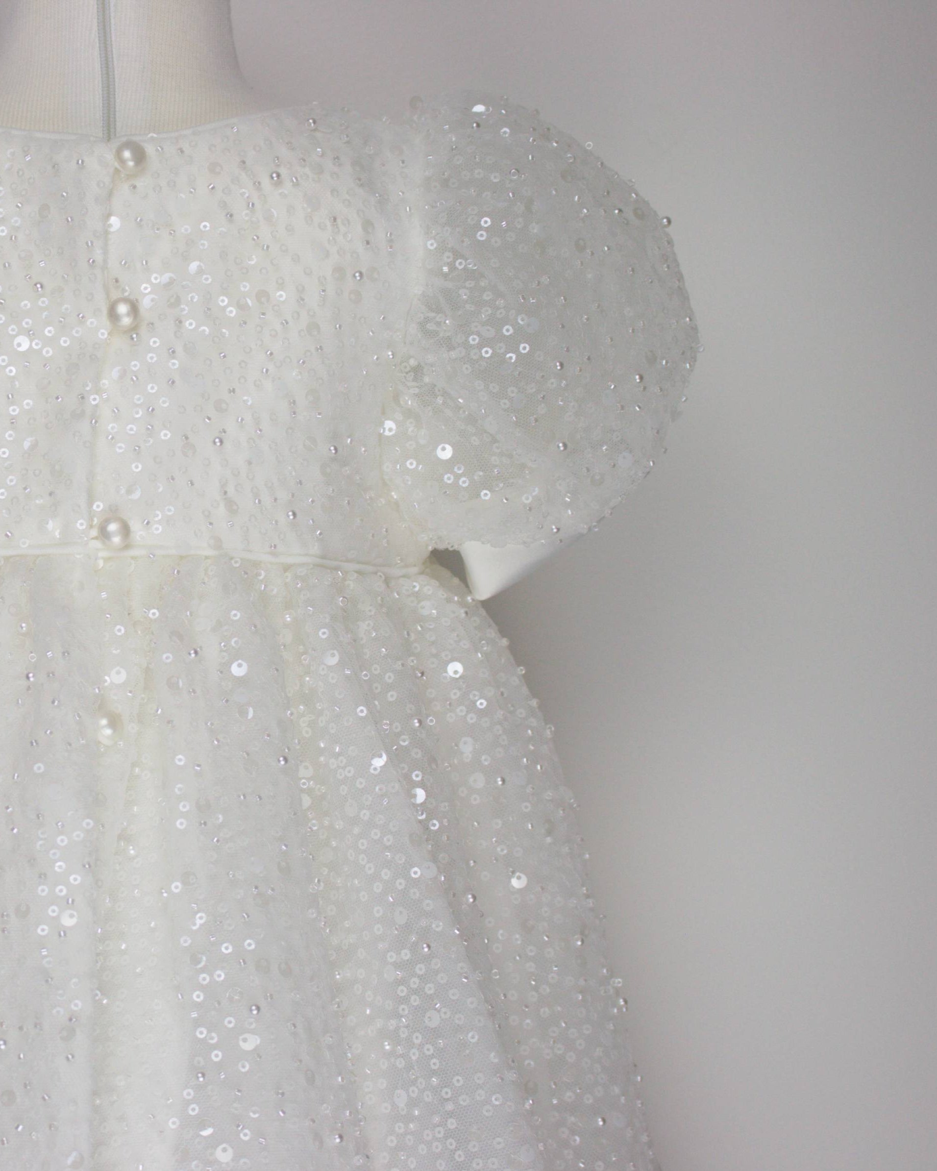 Close-up of the My Blessing Ruth dress’s back bodice featuring delicate lace patterns decorated with reflective sequins, glass seed beads, and miniature pearls.