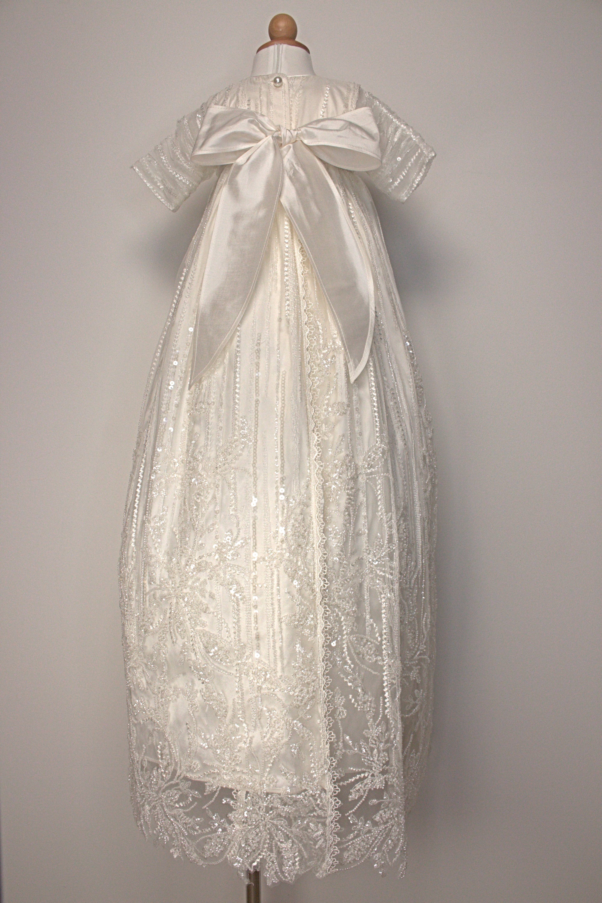 My Blessing Soul ivory christening gown back view showing lace detailing, back closures, and the smooth satin skirt.