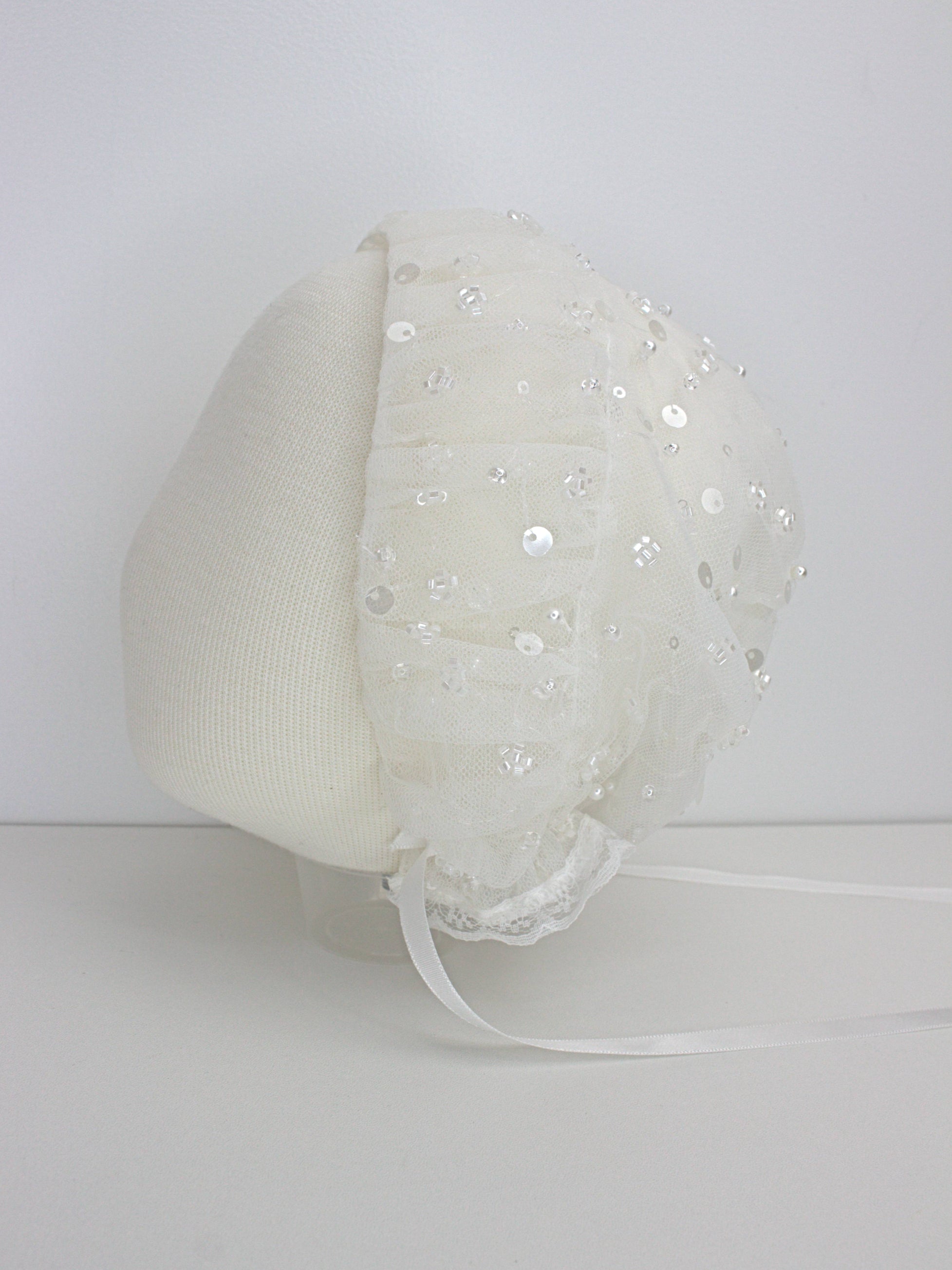 My Blessing ivory christening bonnet with lace embroidery and beadwork showing intricate craftsmanship and satin ties.