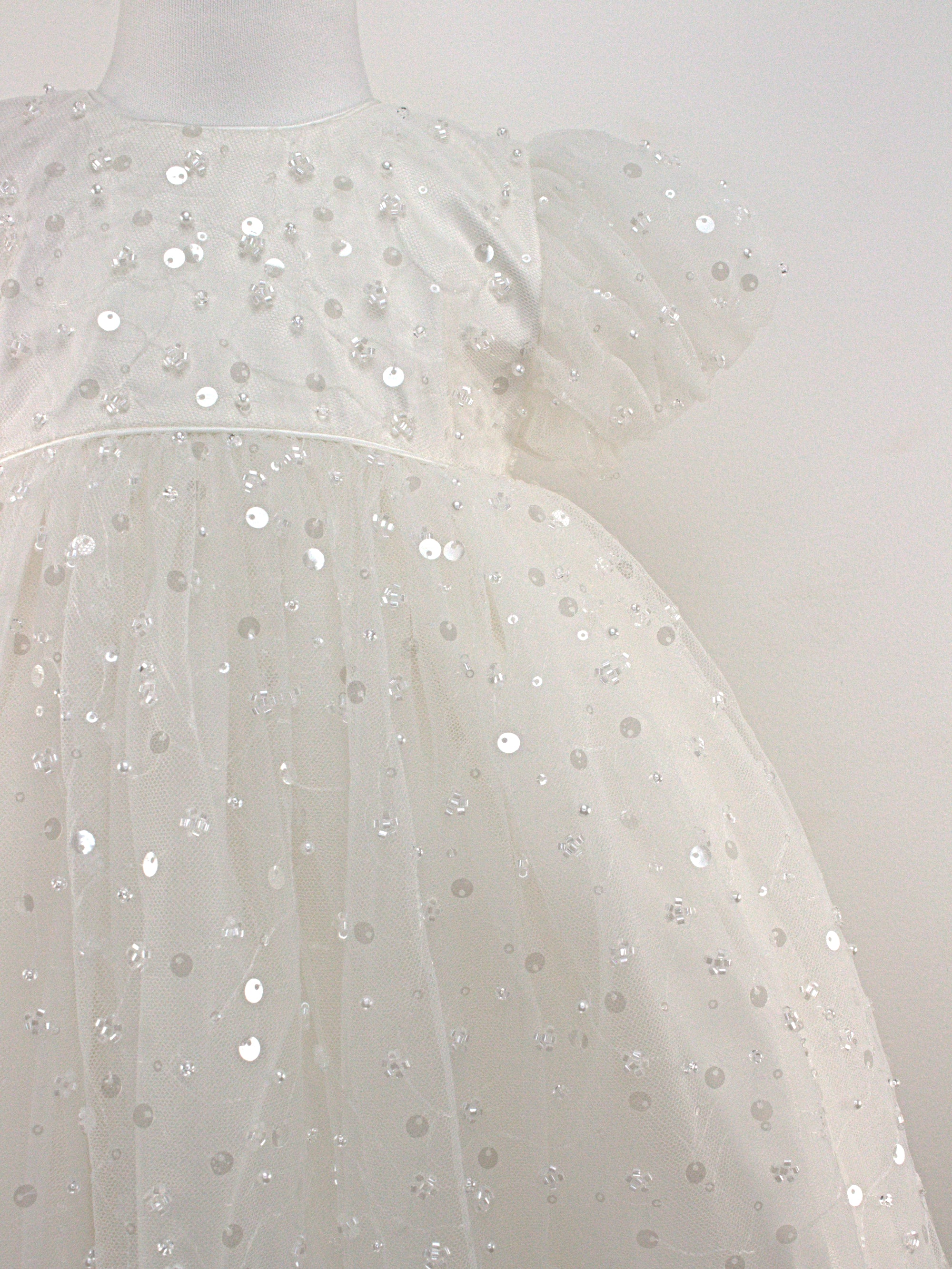 Close-up of the My Blessing Strength christening gown’s front bodice showing detailed floral lace and bead embroidery.