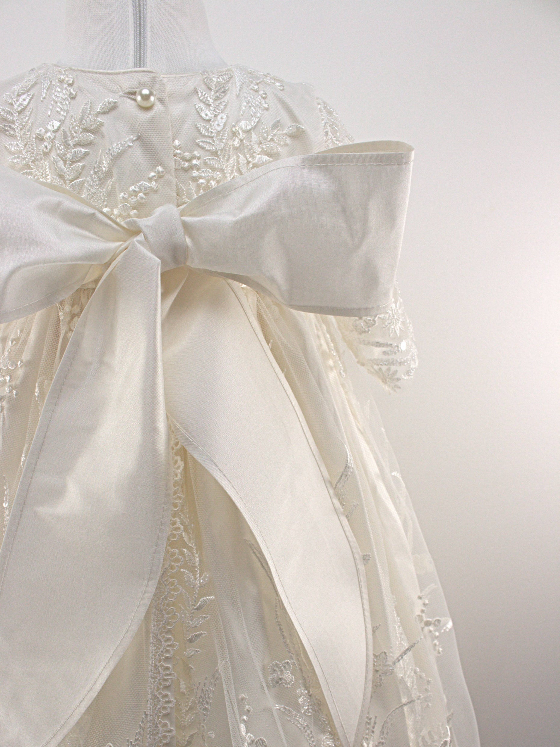 Close-up of the My Blessing Worthy christening gown back bodice featuring delicate lace patterns and button or tie closures.