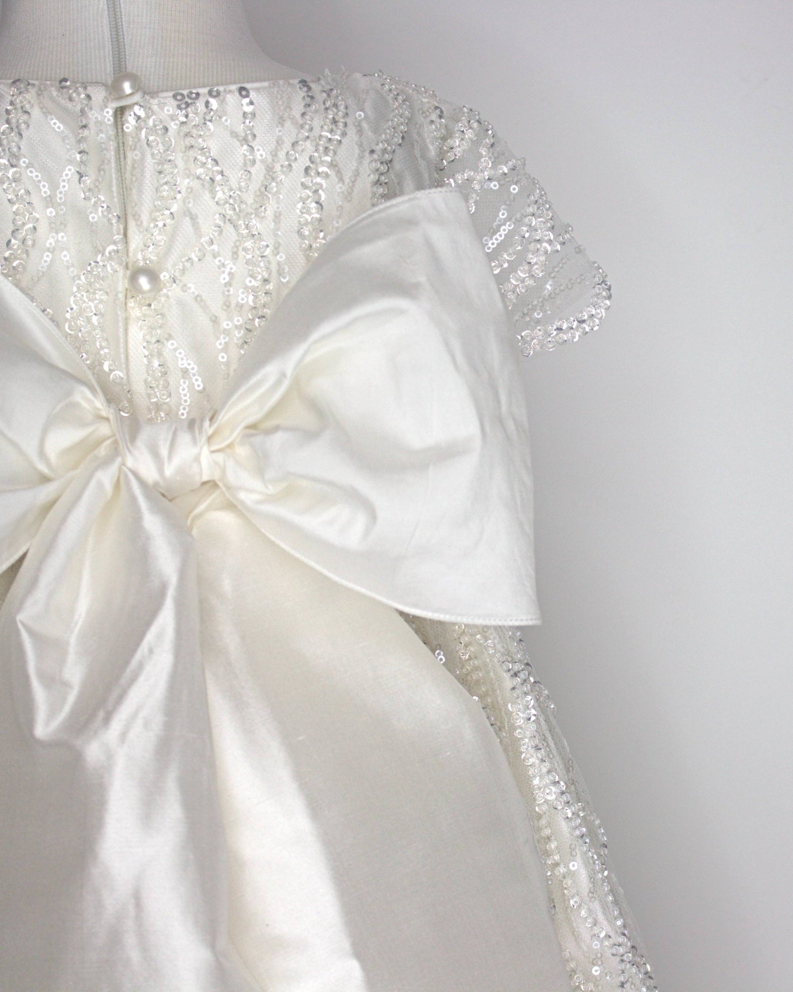 Close-up of the My Blessing Zuriel dress’s back bodice featuring delicate lace patterns embellished with reflective sequins and glass seed beads.