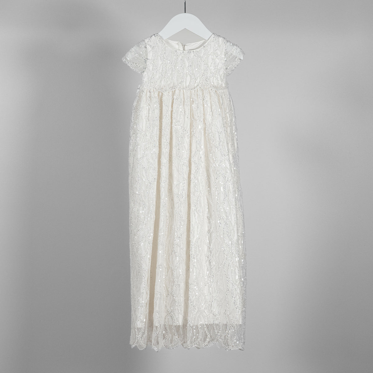 My Blessing ivory christening dress from the Zuriel gown featuring an embroidered lacework adorned with reflective sequins and glass seed beads.