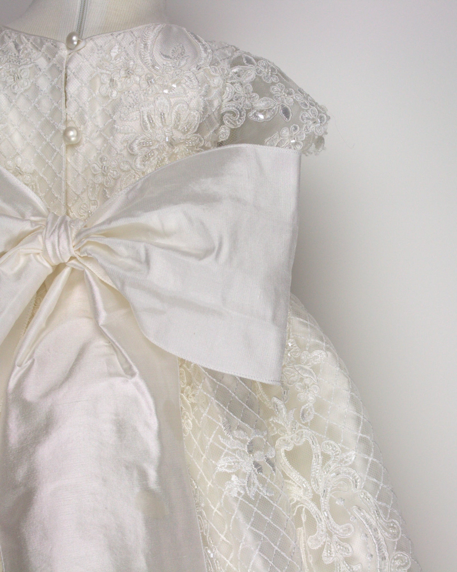 Close-up of the My Blessing Bithiah gown’s back bodice featuring delicate lace patterns over a silk underlay.