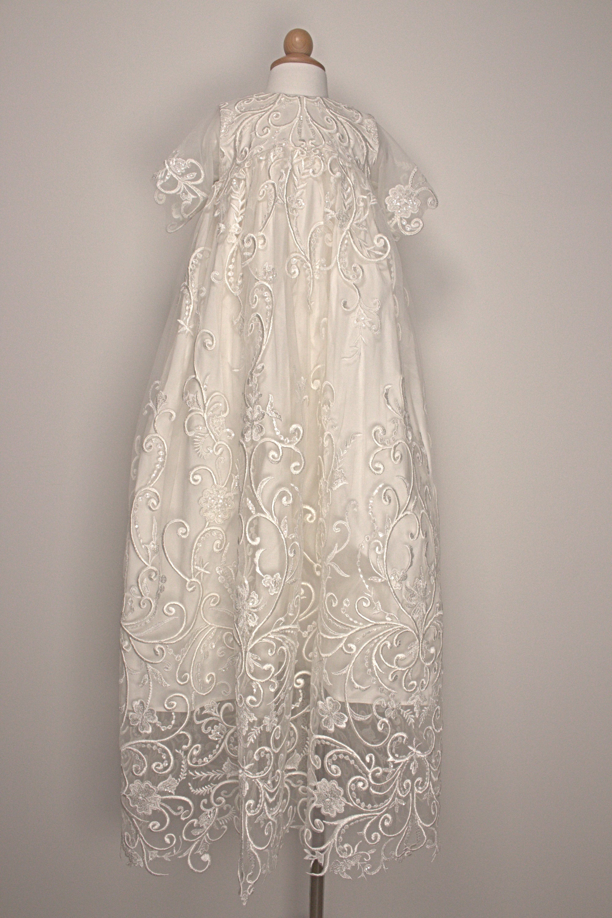 My Blessing Calm ivory christening gown featuring an embroidered lace bodice, short sleeves, and a flowing satin skirt.