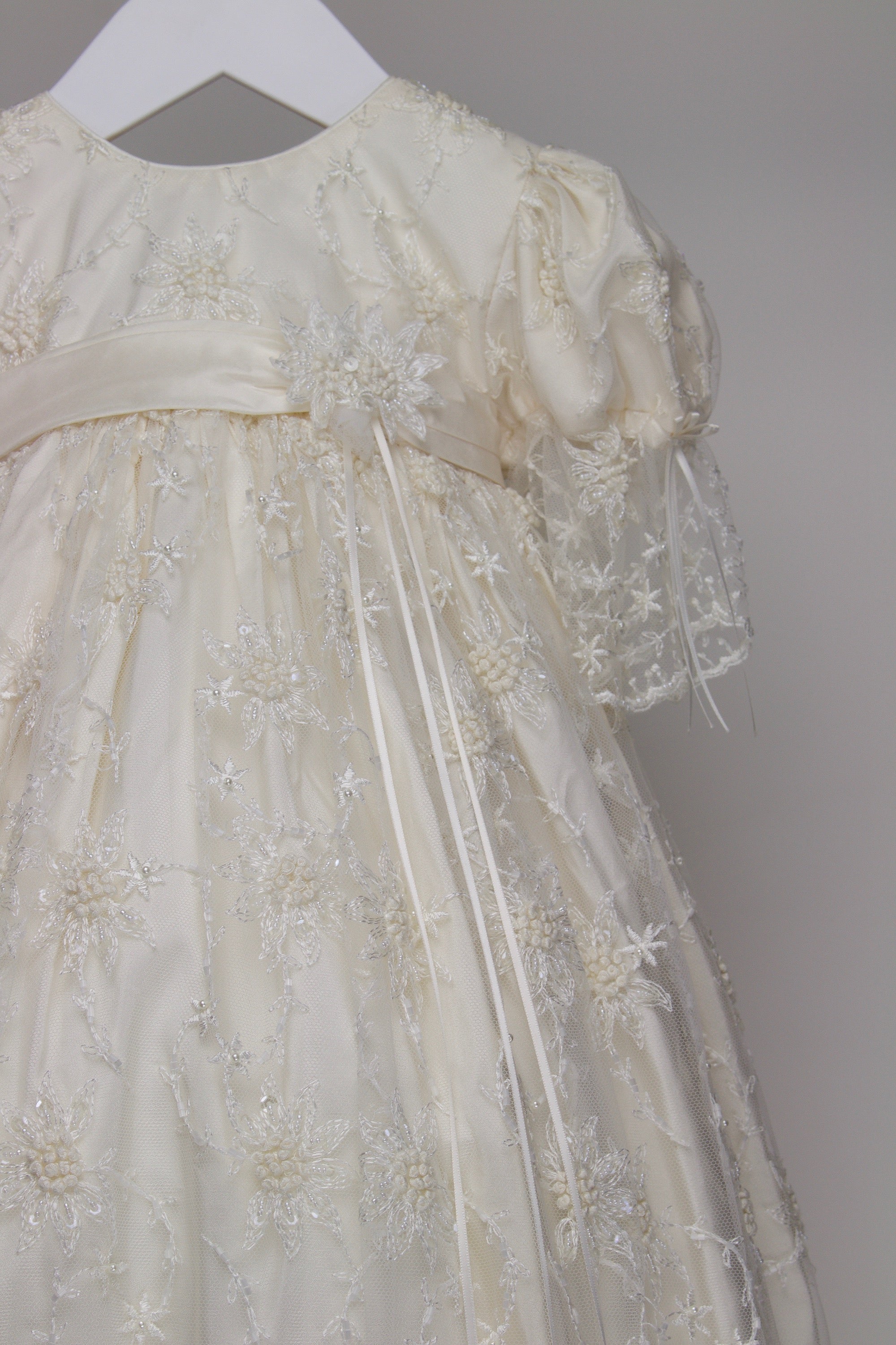 Close-up of the My Blessing Devotion gown showing the intricate European floral lace embellished with subtle glass seed beads.