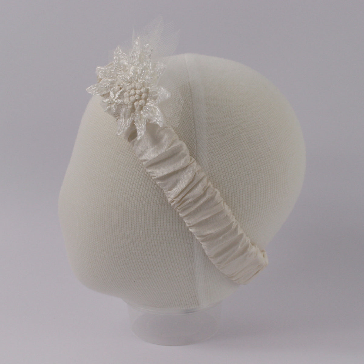 Ivory baby headband from the My Blessing Devotion set featuring a lace floral centerpiece with glass seed bead embellishments.