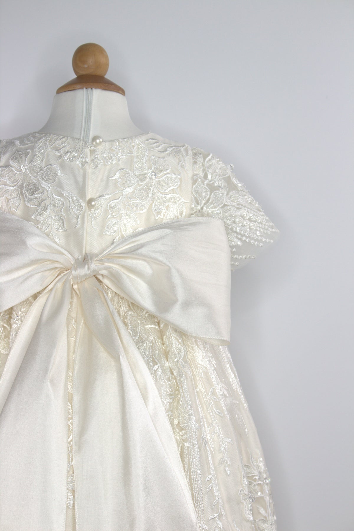 Close-up of the My Blessing Elora gown’s back bodice featuring delicate lace patterns decorated with reflective sequins, glass seed beads, and Swarovski crystal beadwork.