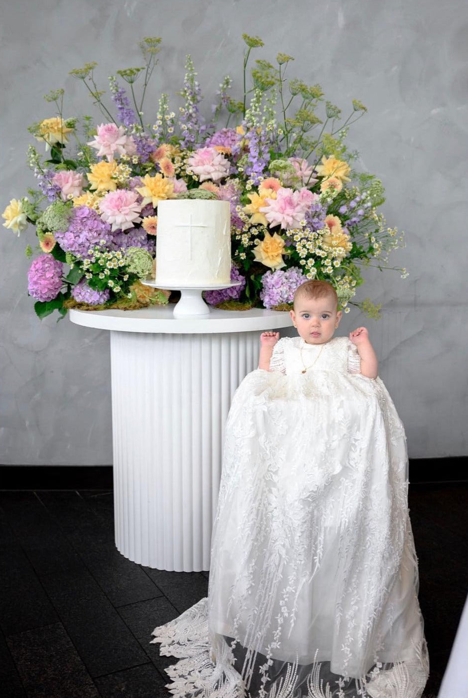 My Blessing ivory christening gown from the Elora set featuring an embroidered lace bodice adorned with reflective sequins, glass seed beads, and Swarovski crystal beadwork.
