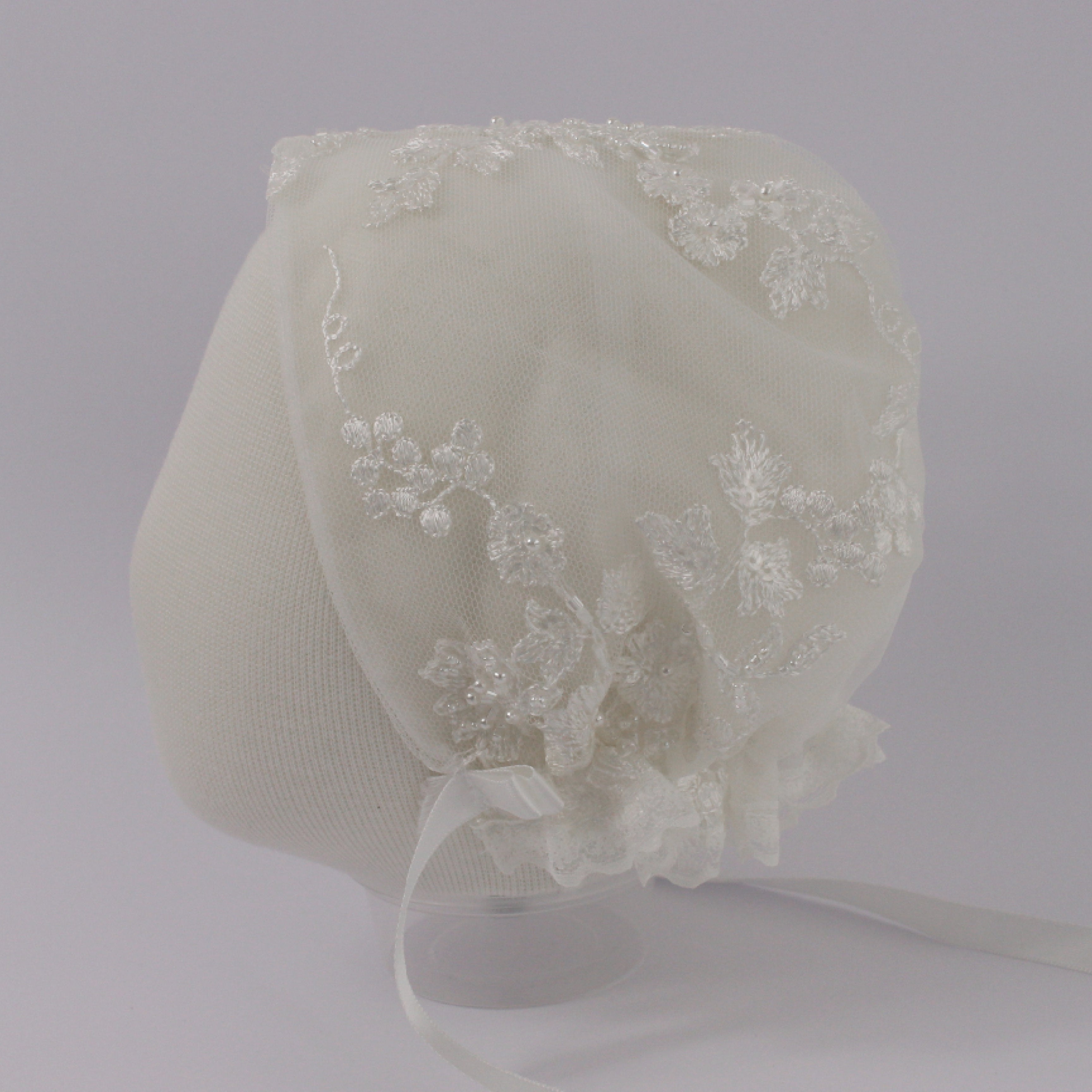 Ivory christening bonnet from the My Blessing Faith set featuring European floral lace with delicate glass seed bead accents.