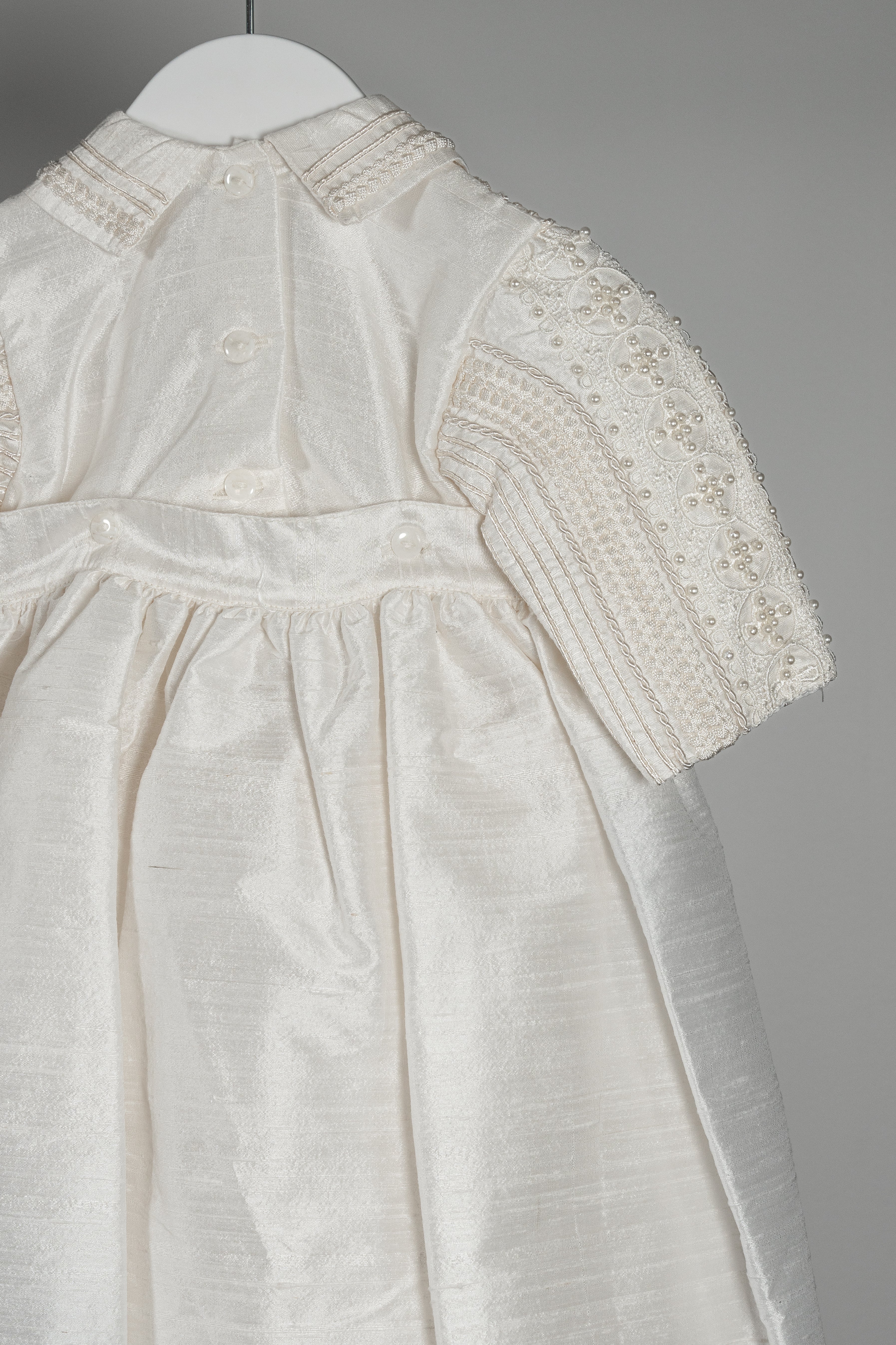 Close-up of the My Blessing Gabriel romper’s back bodice showing the structured silk finish and hand‑finished lacework.