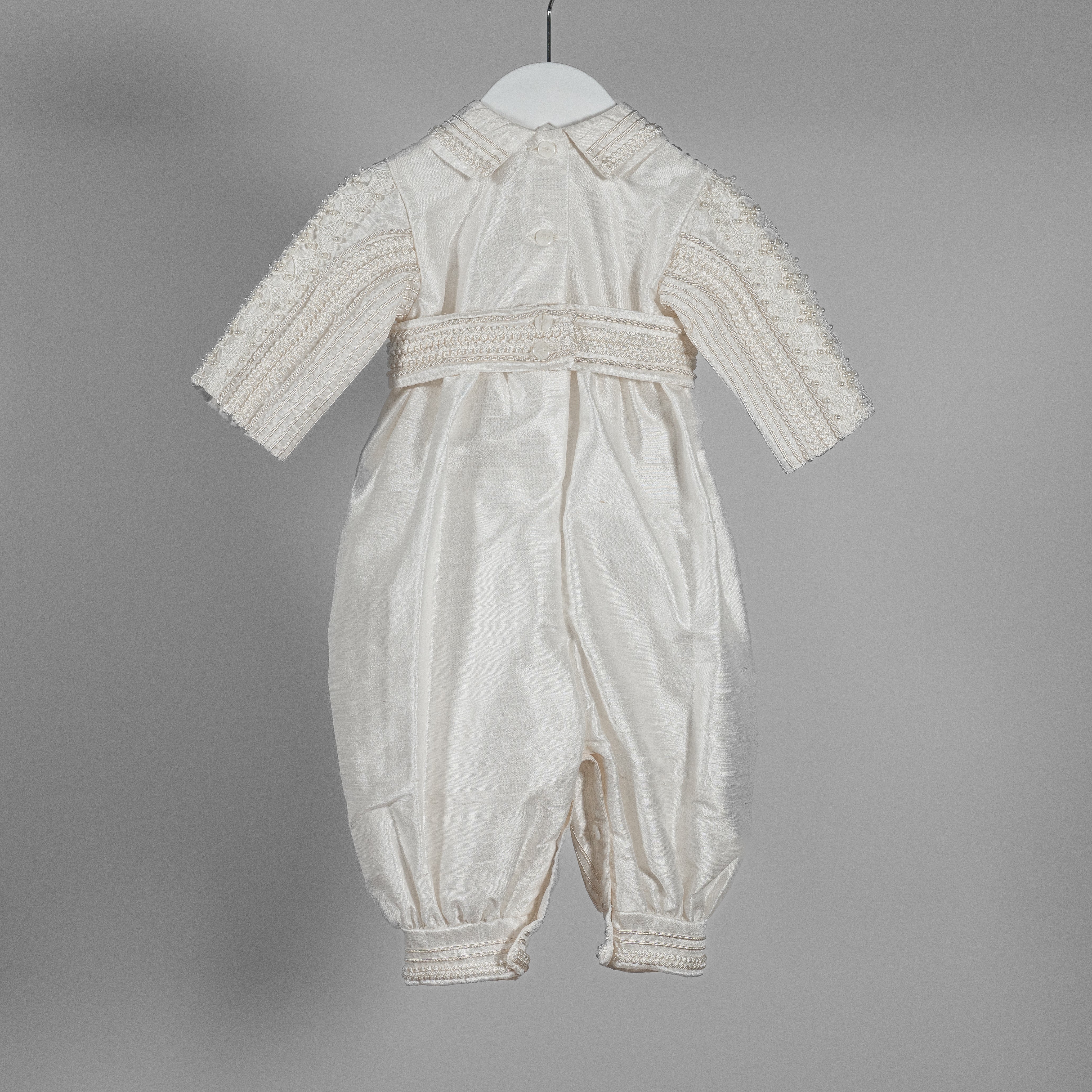 Close-up of the My Blessing Gabriel romper’s back bodice showing the structured silk finish and hand‑finished lacework.