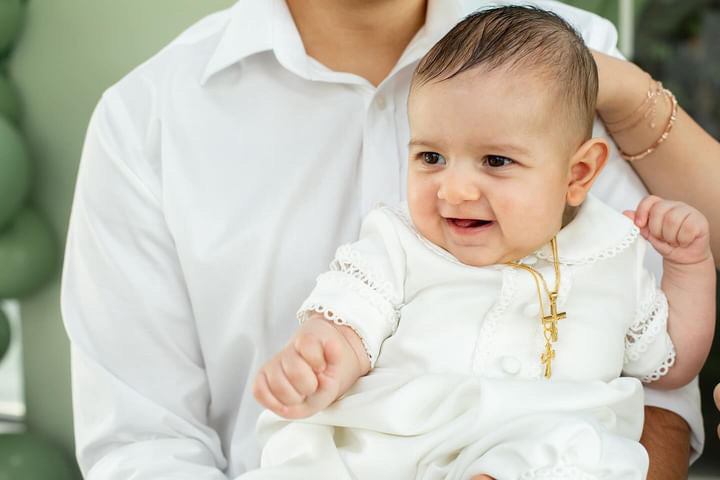Baby boy giggling in the My Blessing Georgie romper, the Mikado fabric holding its crisp, refined shape.