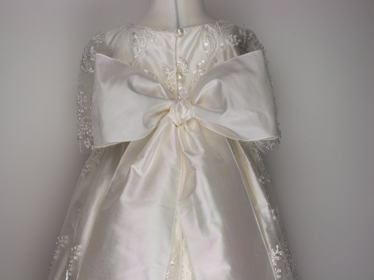 Close-up of the Gianna gown’s back bodice featuring delicate lace patterns decorated with glass seed beads and miniature pearls finished with an extra-large pure silk bow.