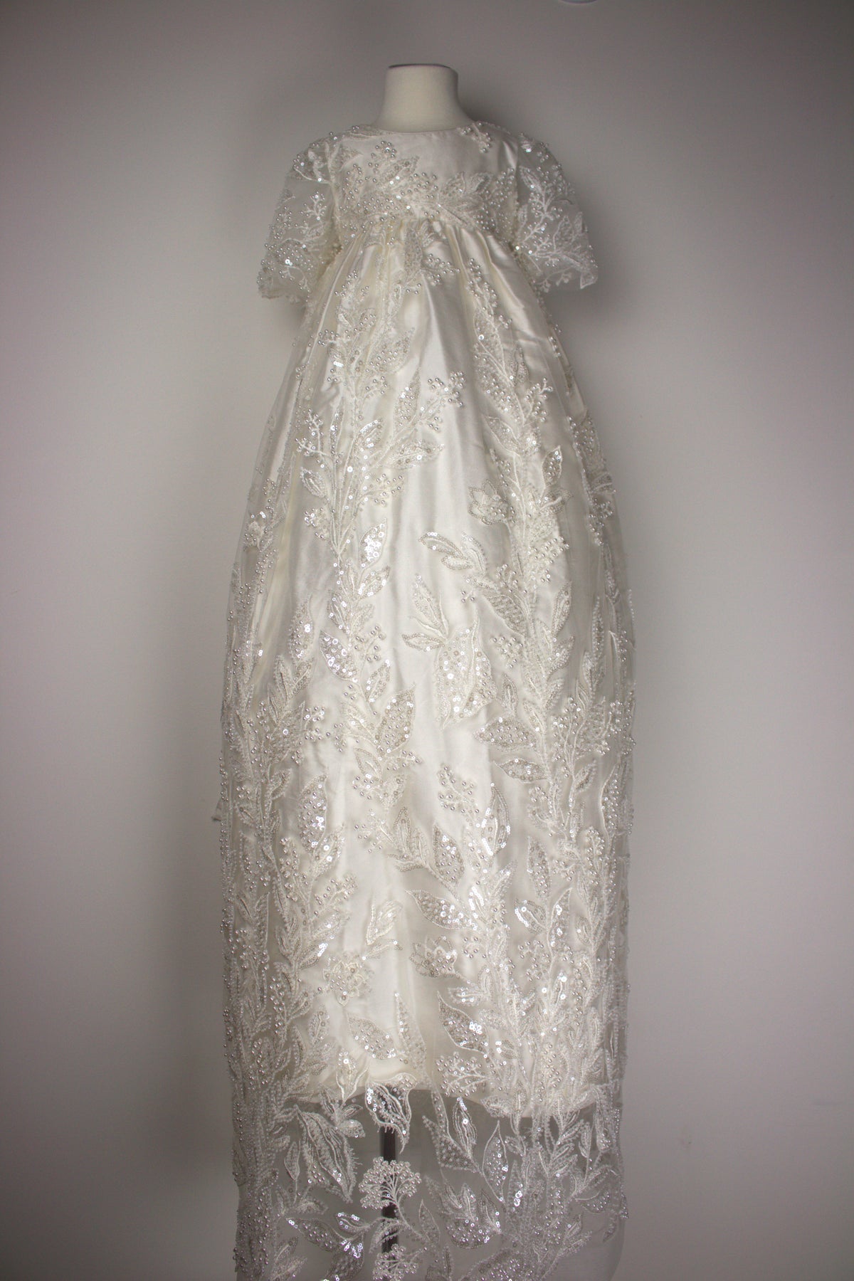 My Blessing ivory christening gown from the Gianna christening gown featuring an embroidered lace adorned with glass seed beads and miniature pearl detailing.