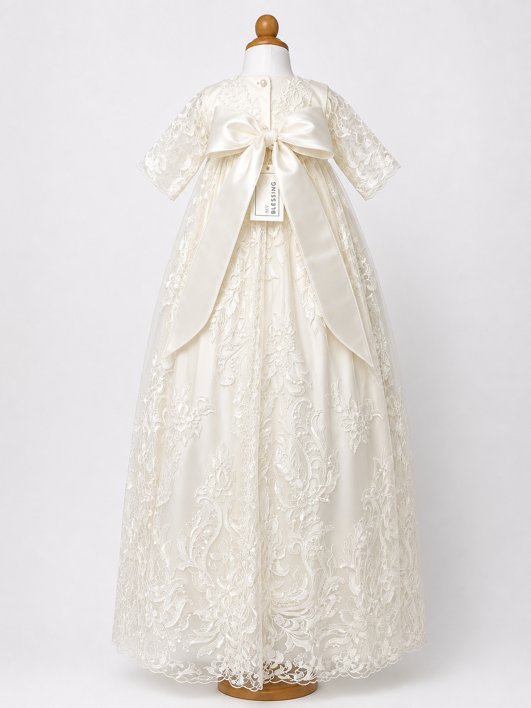 Back full-length image of the My Blessing Grateful gown’s back bodice featuring delicate lace patterns and pearl button closures and silk bow.