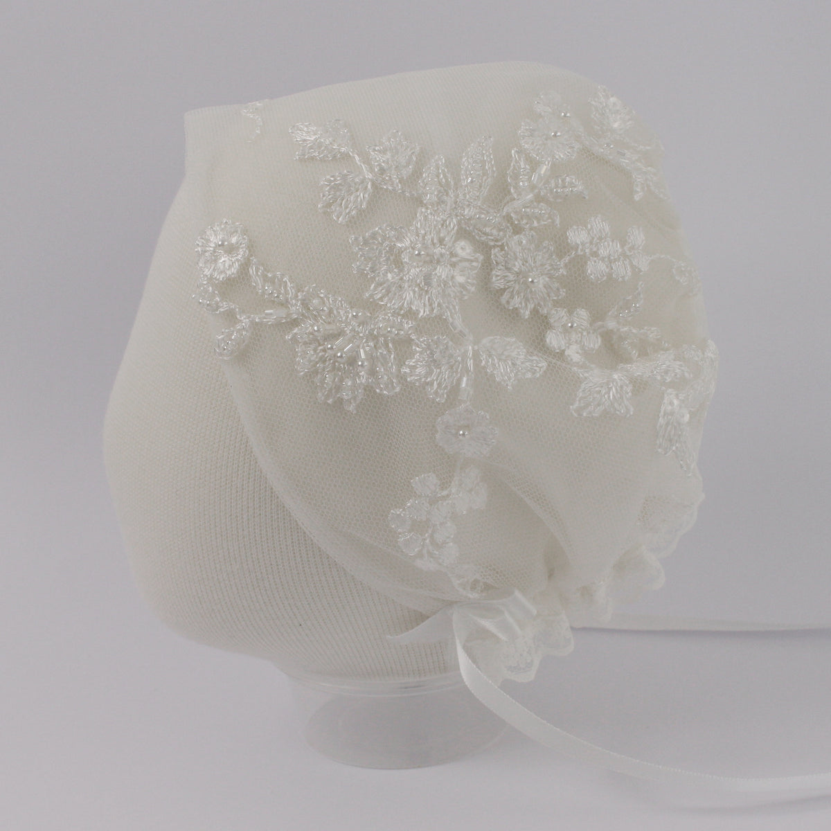 My Blessing ivory christening bonnet from the Humble set featuring European floral lace with hand‑finished pearls, beads, and soft reflective sequins.