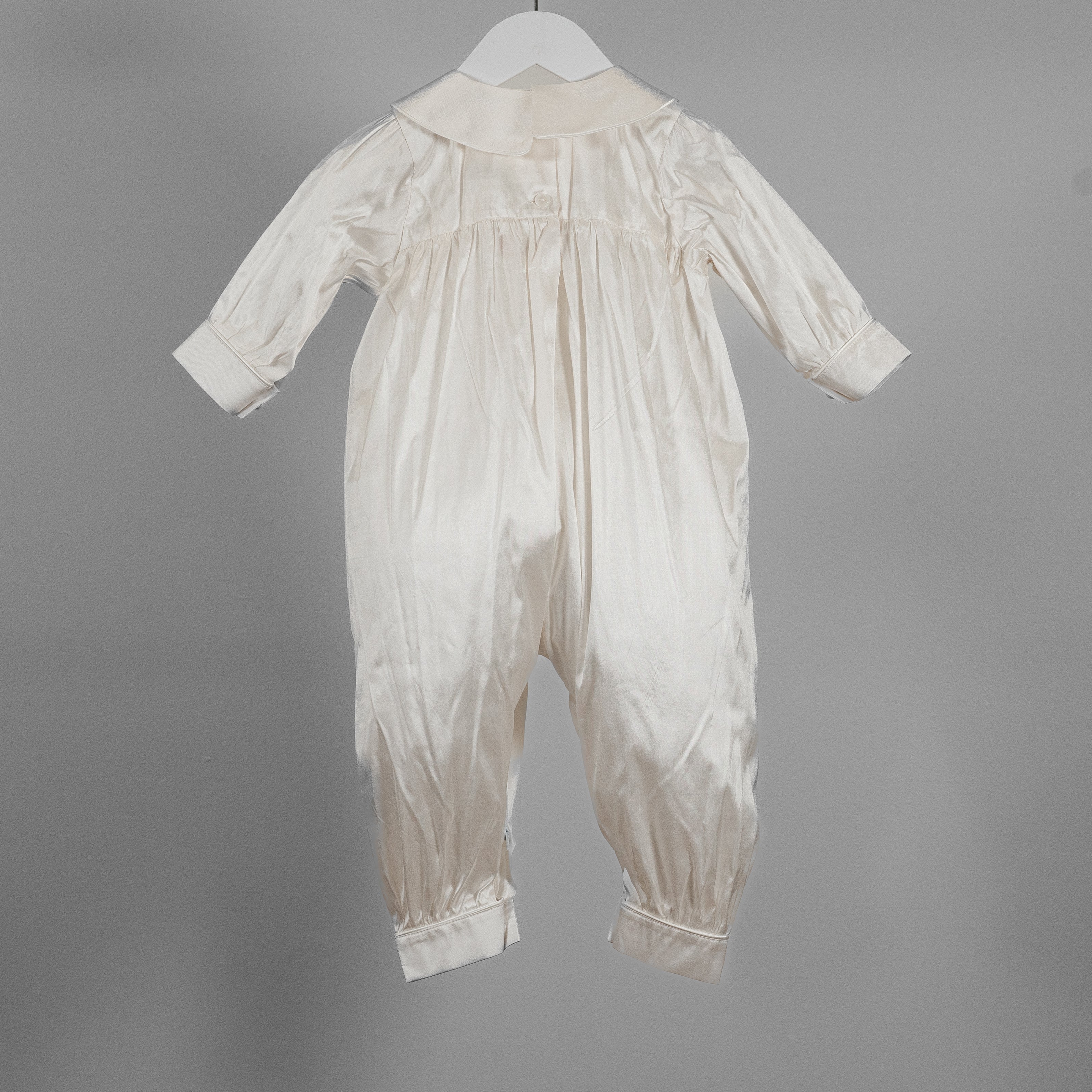 Back view of the My Blessing Lael baptism romper featuring smooth Dupioni silk and fine piping along the cuffs.