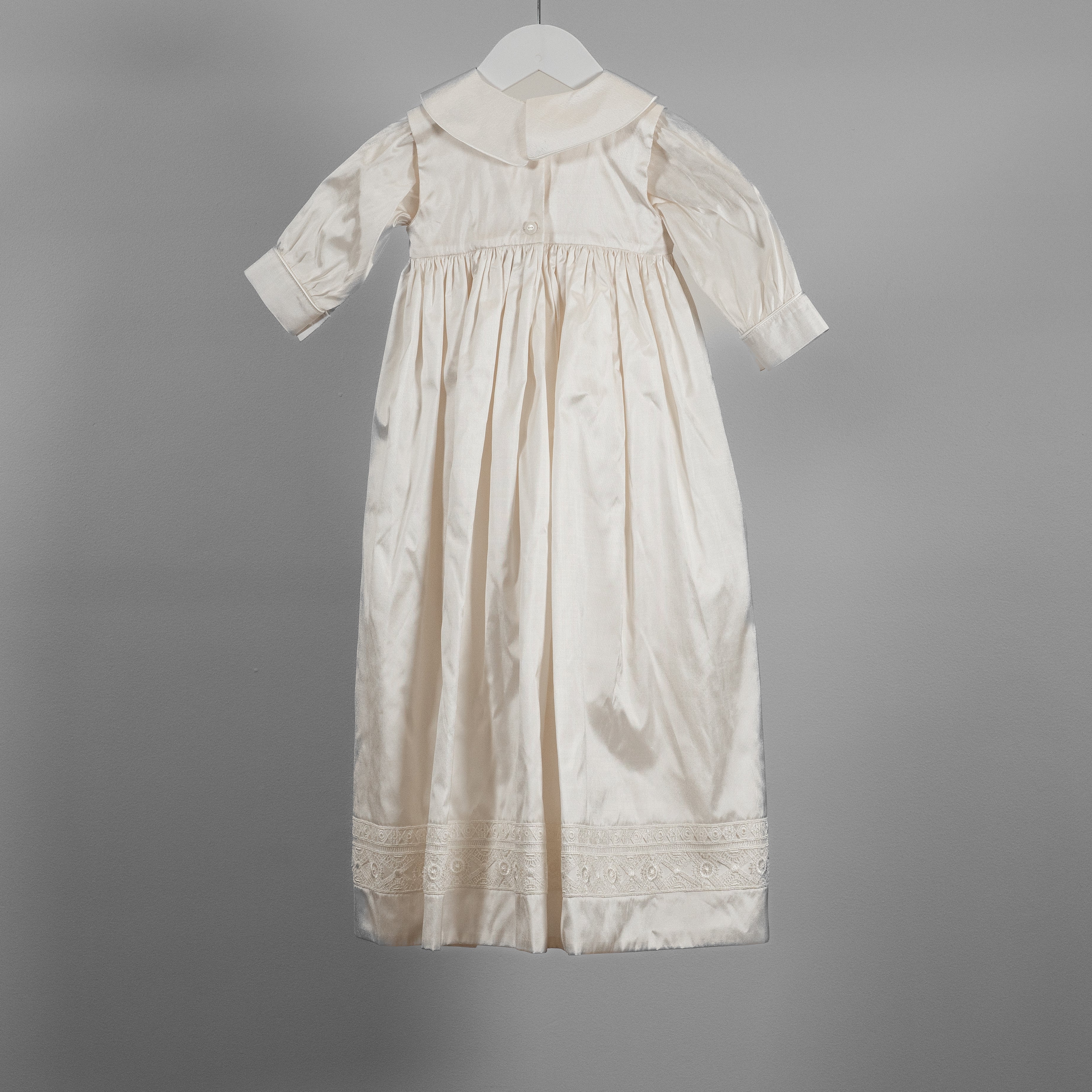 Back view of the My Blessing Lael baptism romper featuring smooth Dupioni silk and fine piping along the cuffs.