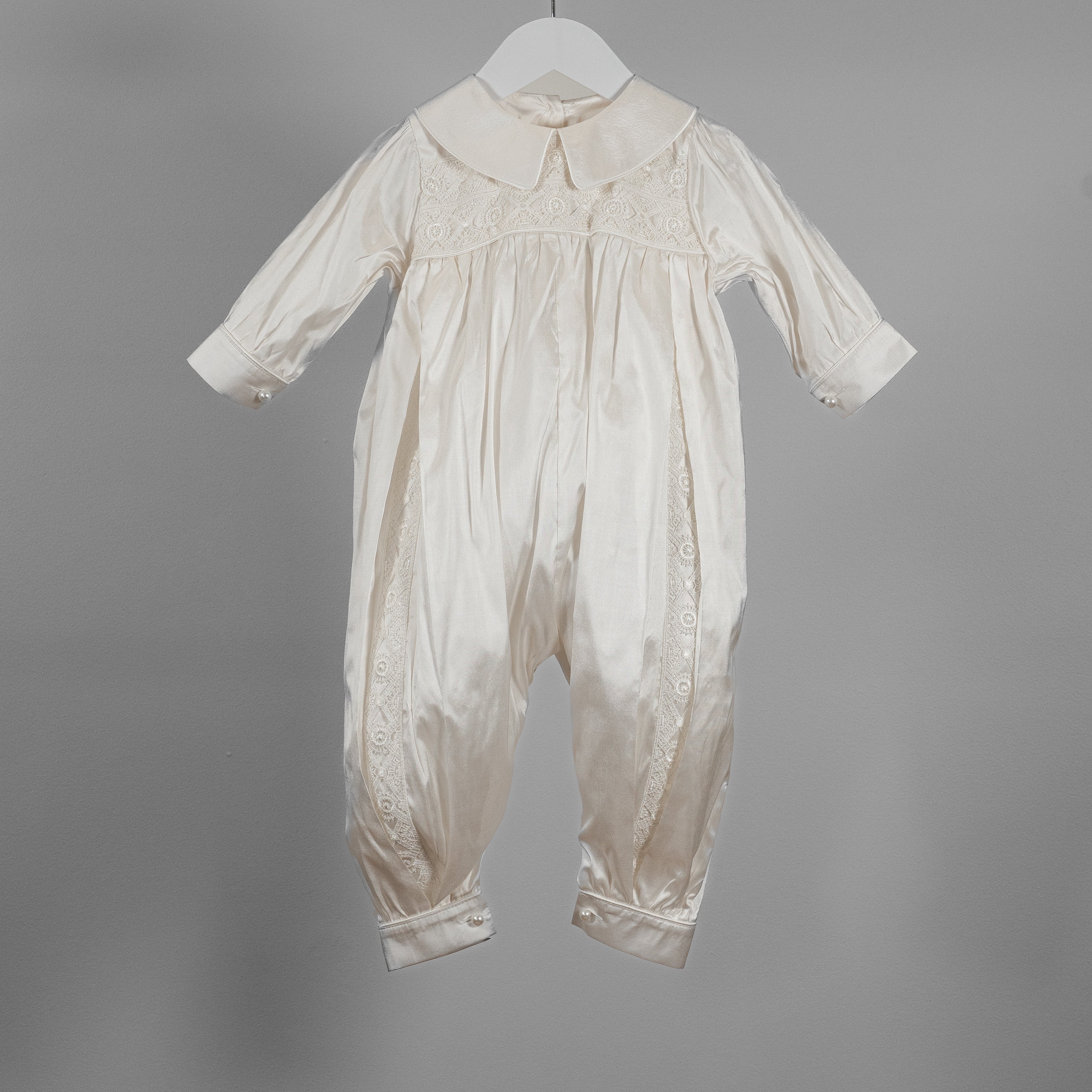 My Blessing ivory Lael baptism romper crafted from 100% pure Dupioni silk with delicate lace detailing across the bodice and leg inserts.