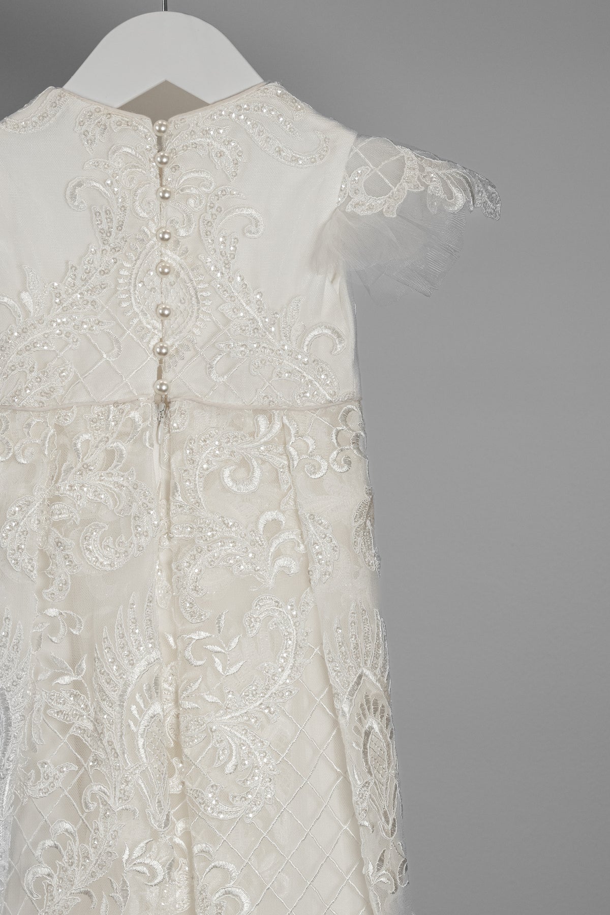 Close-up of the My Blessing Lilly gown’s back bodice featuring delicate lace patterns over a cotton underlay.