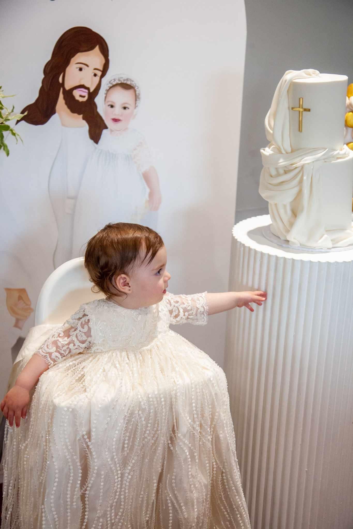 Side angle of the My Blessing Nineveh christening gown showing the embroidered lace bodice and the transition into the flowing silk‑underlay skirt.
