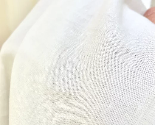 Macro shot of the My Blessing Noa gown’s fine linen overlay highlighting its natural, breathable texture.