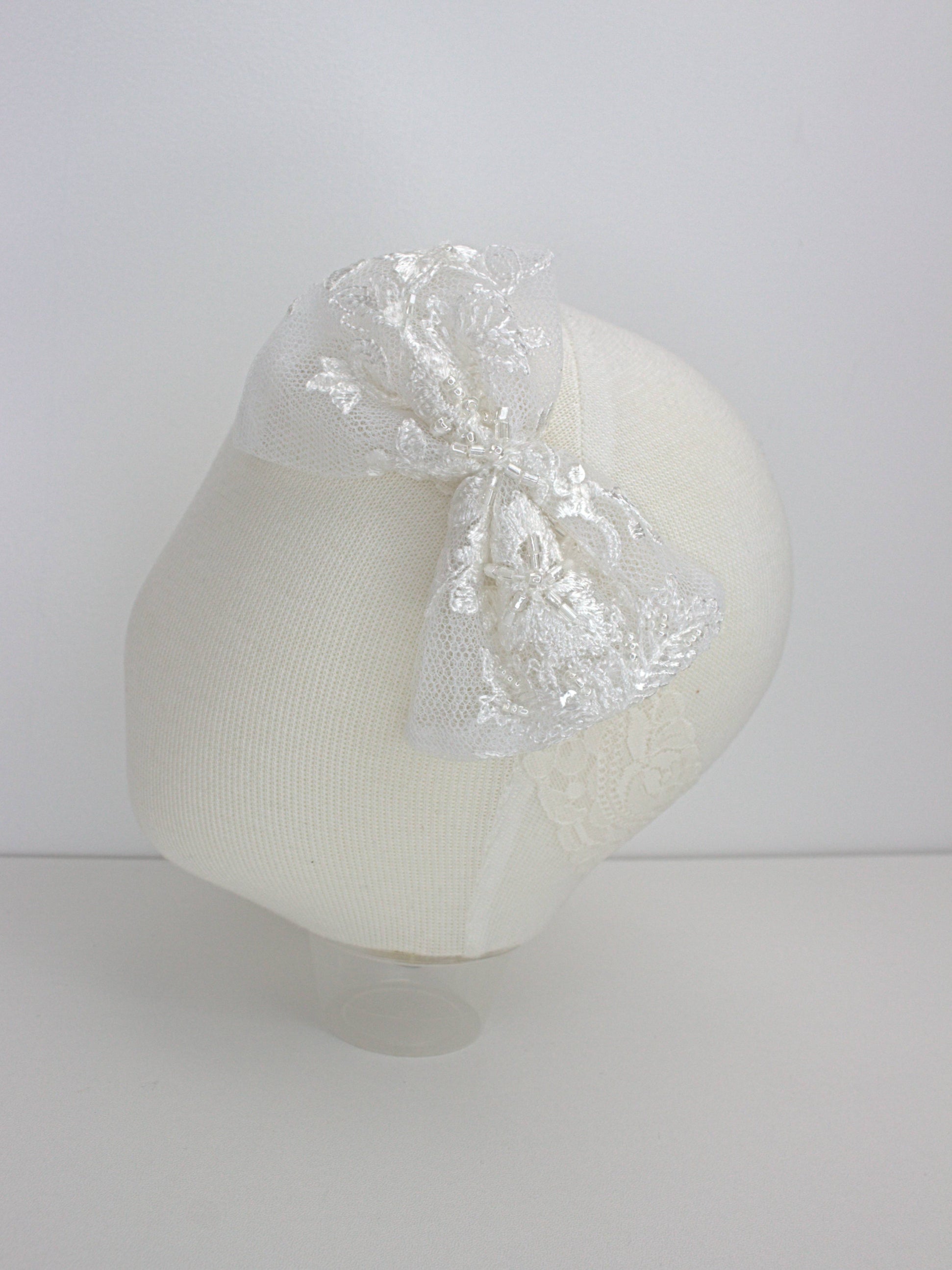 My Blessing ivory baby headband with a lace floral embellishment from the Noble christening set.