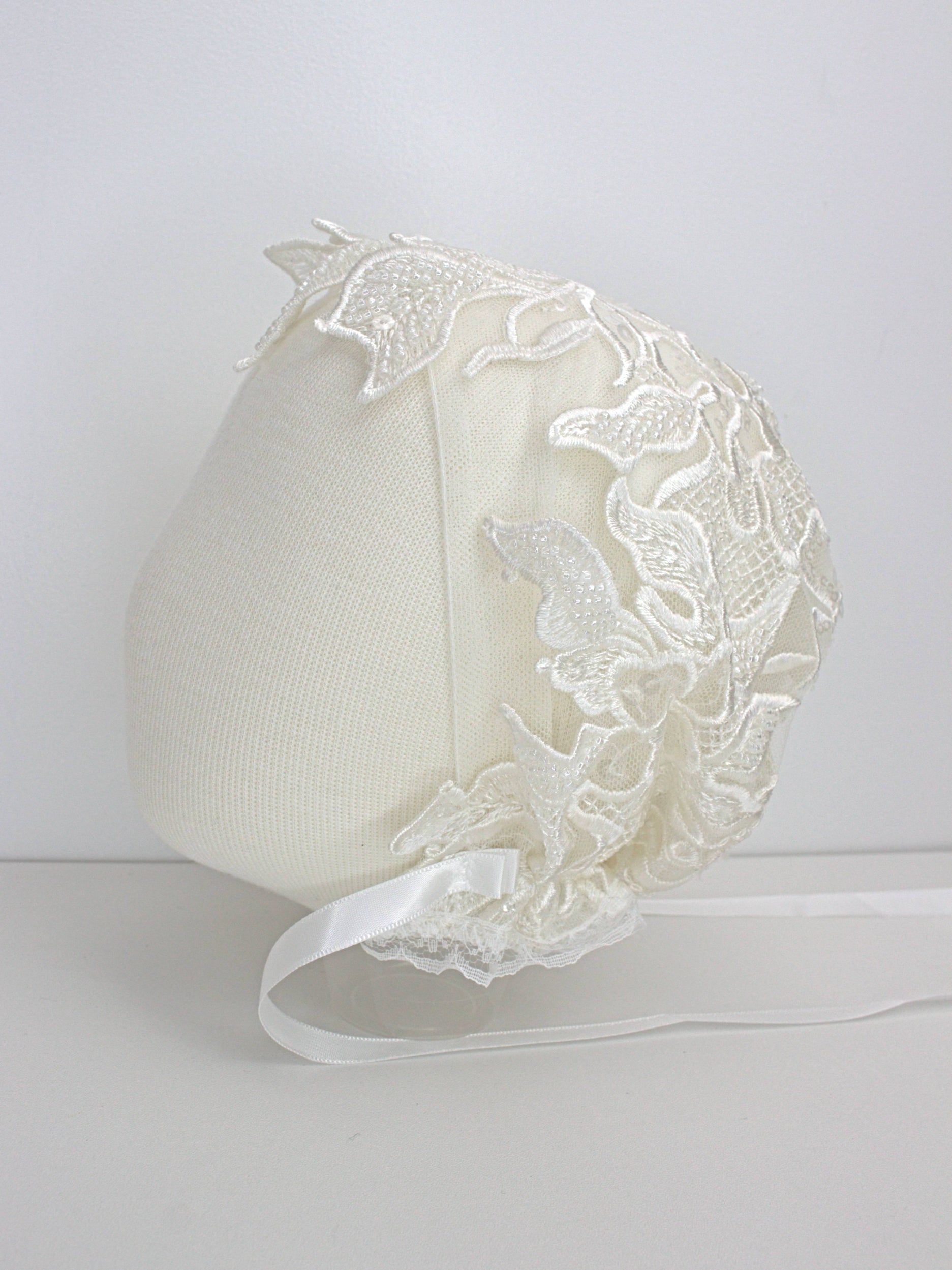 My Blessing ivory christening bonnet from the Praise set with lace embroidery and satin ties.