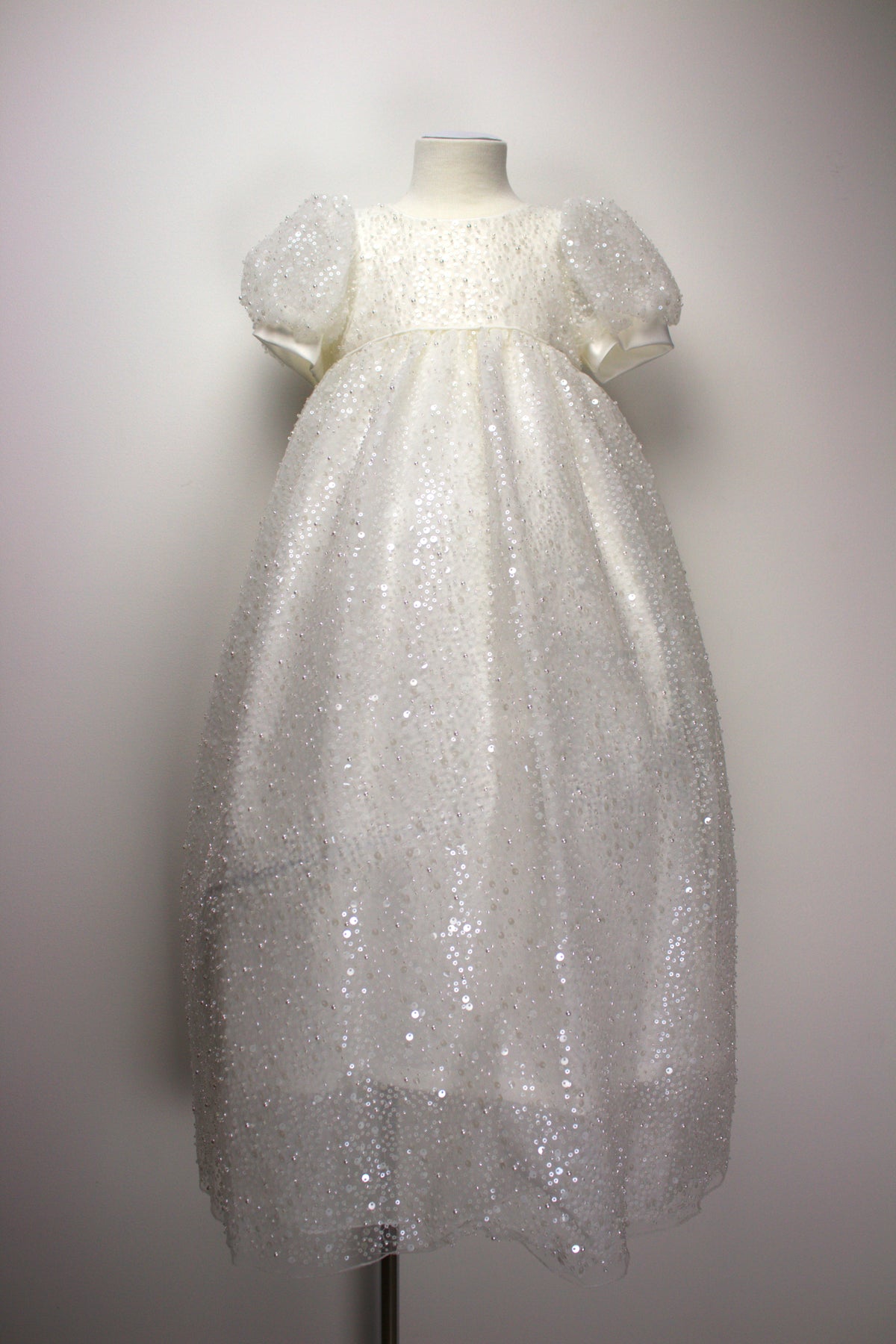 My Blessing ivory christening dress from the Ruth set featuring an embroidered lace bodice adorned with reflective sequins, glass seed beads, and miniature pearls.