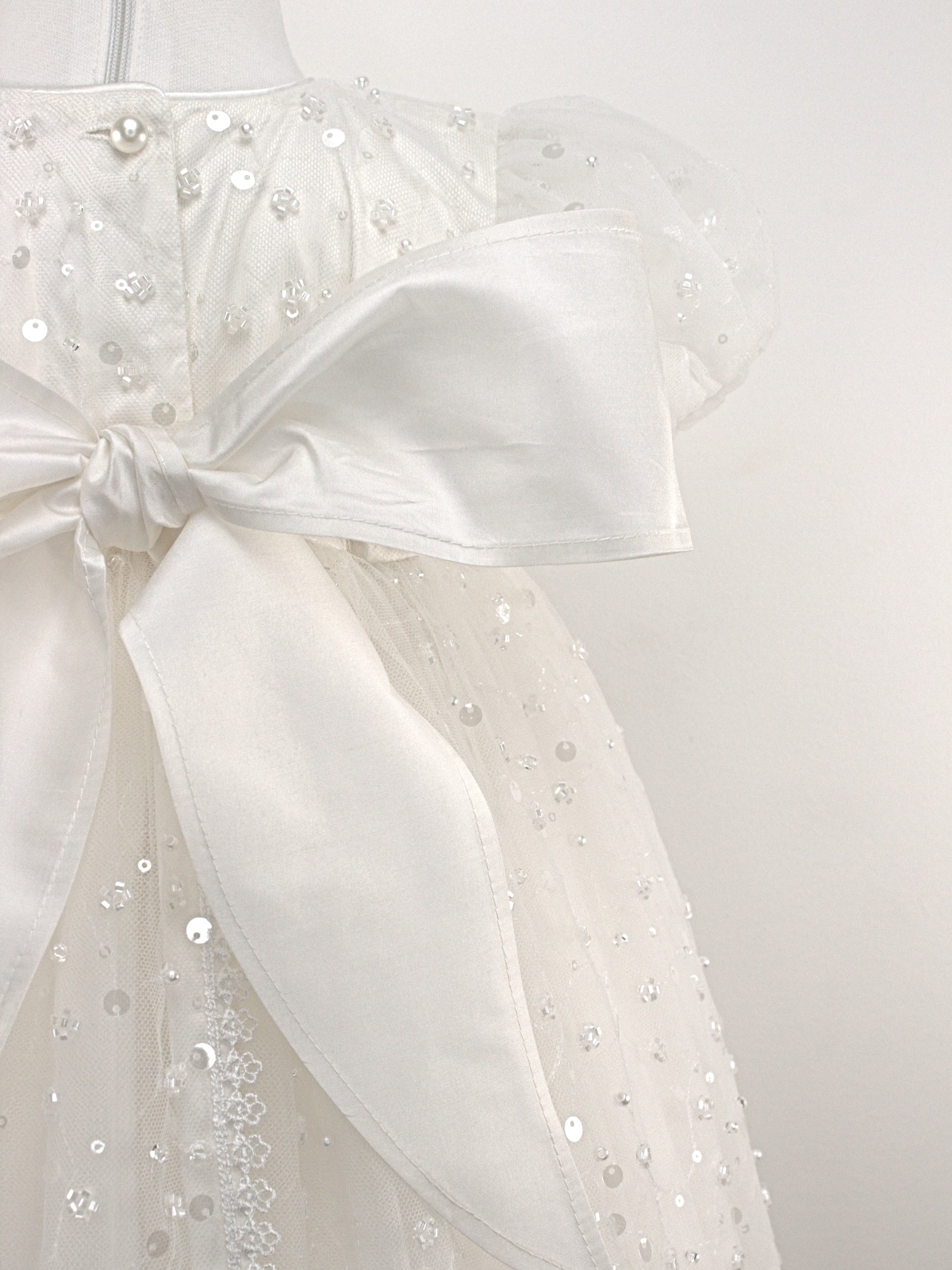 Close-up of the My Blessing Strength christening gown back bodice featuring delicate lace patterns and button or tie closures.