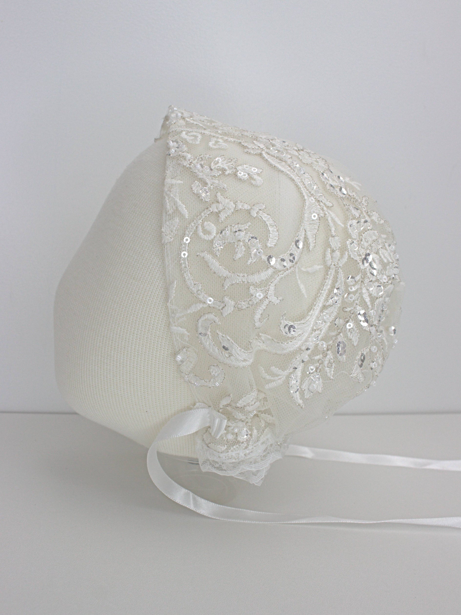 My Blessing ivory christening bonnet from the Wholesome set with lace embroidery and satin ties."